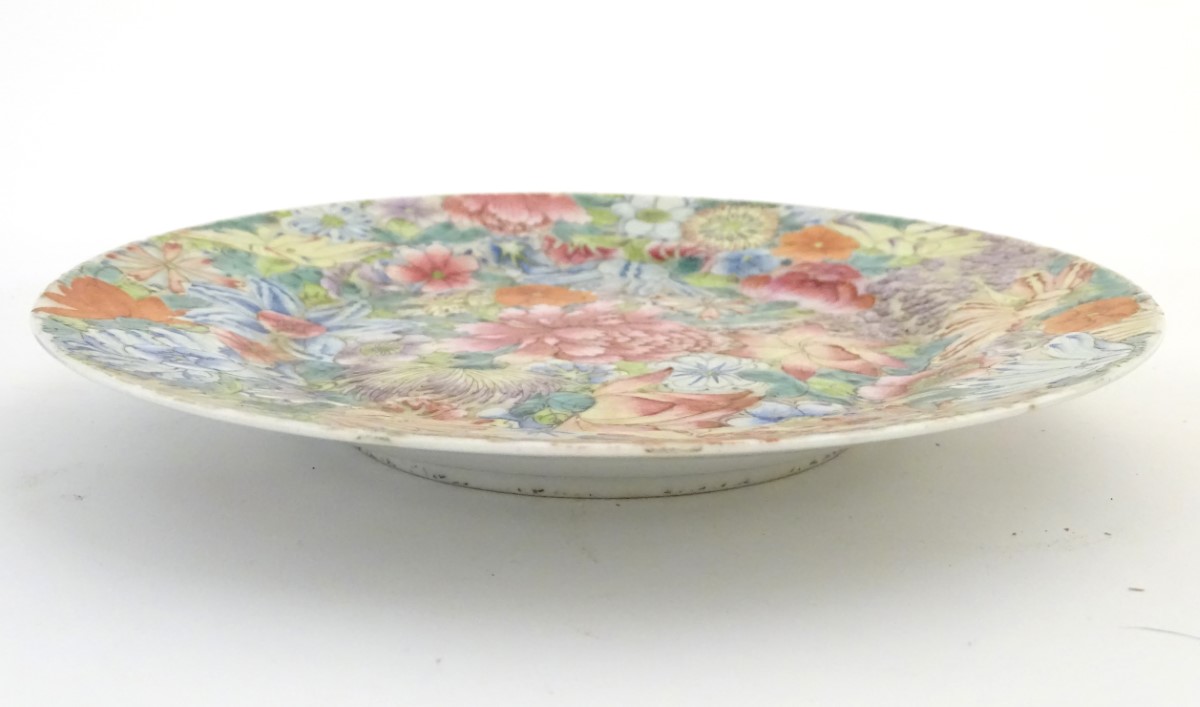 An Oriental plate decorated with stylised flowers, with a scrolling floral design to reverse. - Image 5 of 11