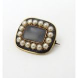 A 19thC mourning brooch set with central lock of hair boarded by pearls and black enamel detail.