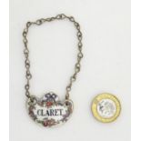 Wine label / bottle tag: a porcelain Crown Staffordshire shaped 'Claret' label with brass bottle