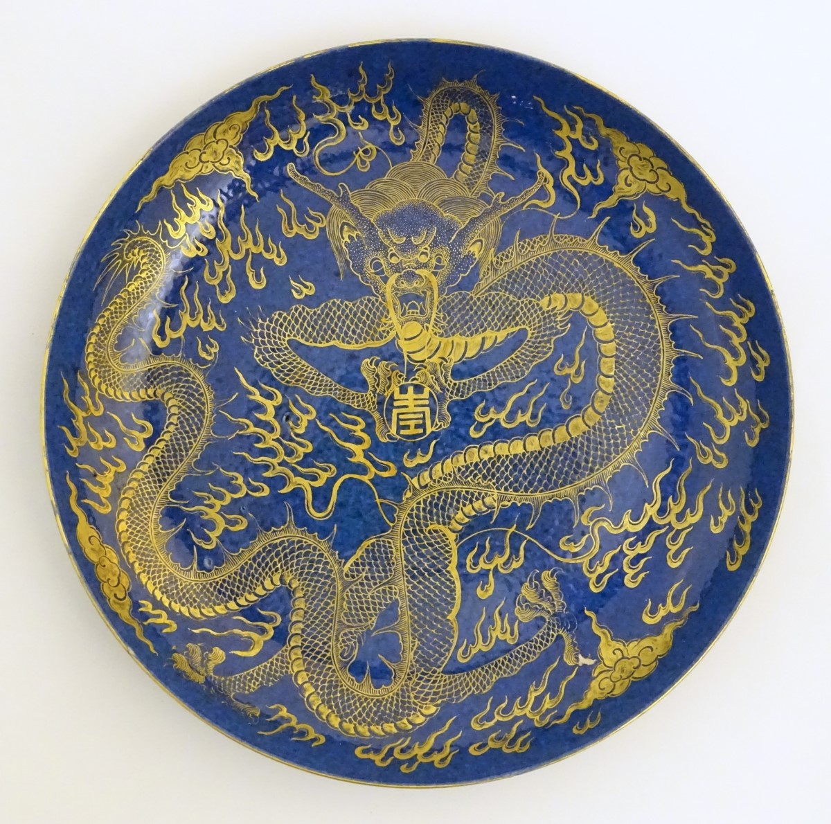 A Chinese dish decorated with a gilt dragon on a blue ground. Approx. 10 1/4" diameter.