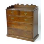 A late 19thC oak chest of drawers with a shaped gallery,