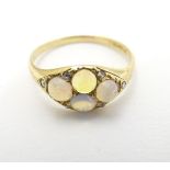 A late 19thC / early 20thC gold ring set with 4 water opal cabochon and 4 diamonds.