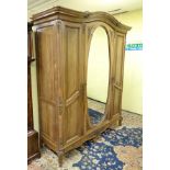 An early 20thC triple armoire with painted floral decoration and applied mouldings,