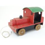 A pull along scratch-built wooden toy train, painted red, green and black.