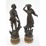 A pair of patinated Spelter figures of a Fisherman with a sea net and fisherwoman holding a landing