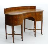 An early 20thC mahogany sideboard / dressing table of kidney form,