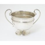 A twin handled trophy cup hallmarked London 1932 maker Sir John Bennett Ltd.