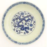 A Chinese blue and white dish decorated with dragons, and scrolling flowers.