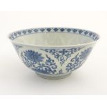 A Chinese blue and white bowl decorated with flowers and scrolling vines. Character marks to base.