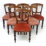 A set of six late Victorian mahogany dining chairs with carved curved backrests,
