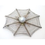 A silver brooch formed as a spiders cobweb with spider to centre set with pearl to body.