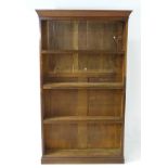 An early 20thC bookcase with adjustable shelving above a moulded cornice,
