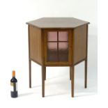 An Edwardian mahogany hexagonal coffee table / cabinet with two glazed doors and raised on square