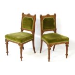 A pair of late 19thC / early 20thC oak Gothic Revival chairs with pointed cresting rail and
