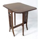 An early 20thC mahogany drop flap table with canted leaves,