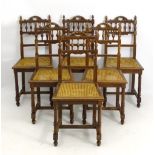 A set of six oak dining chairs with carved cresting rail and spindled backrest with turned uprights