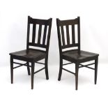 A pair of early 20thC Arts and Crafts ebonised slat back chairs with shaped top rail,