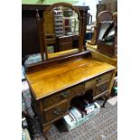 A 20thC walnut dressing table with a bevelled glass mirror,