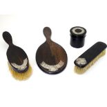 Ebonised dressing table items comprising hand mirror, brushes and pot,