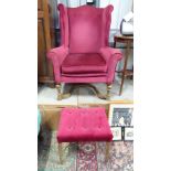 A burgundy upholstered wing back arm chair with X-frame base,