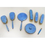 A silver plate and blue enamel dressing table set, comprising mirror, 5 brushes,