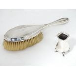 A silver backed hairbrush together with the base of a silver plate pepperette (2)