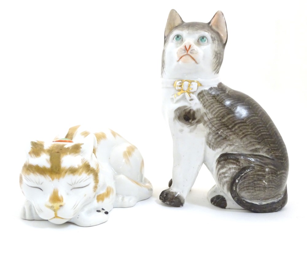 Two ceramic models of cats, one seated, one recumbent. Height of the seated model: approx.