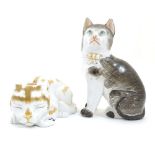 Two ceramic models of cats, one seated, one recumbent. Height of the seated model: approx.