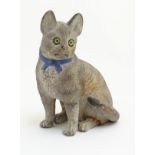 A ceramic model of a seated cat with large ears and a blue bow collar. Approx. 6 ¾” high.