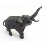 A patinated bronze model of an elephant with its trunk up, signed to tablet under, 12" long.