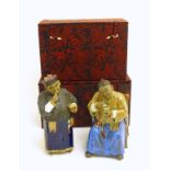 Two ceramic figures of Chinese men in traditional dress drinking tea, one seated,