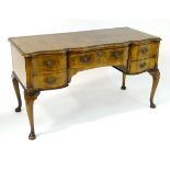 An early / mid 20thC walnut dressing table with a serpentine shaped front,