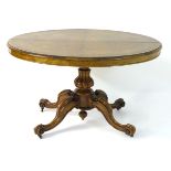 A late 19thC walnut loo table with a gadrooned pedestal base and standing on four carved legs