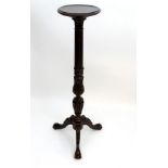 An early 20thC oak Edwards & Roberts torchiere with a dished top above an acanthus carved stem with