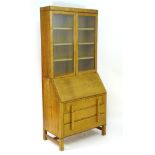 An early / mid 20thC oak bureau bookcase, the top section is glazed with adjustable shelving within,