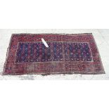 Carpet rug: An old handmade Persian rug having a dark blue central ground with further reds and