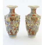 A pair of Japanese Satsuma vases, decorated with figures in a lavish interior,