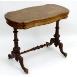 A late 19thC burr walnut card table with two turned carved supports above shaped cabriole legs