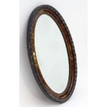 An early 20thC oval mirror with carved wooden moulding's and painted decoration to the frame.