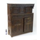 A 17thC and later oak court cupboard with decorative carving to the carcass and panelled doors.