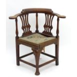 A late Georgian corner chair with turned supports, pierced backsplats and swept arm rests,