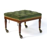 A Victorian mahogany footstool with a deep buttoned upholstered seat above tapering legs