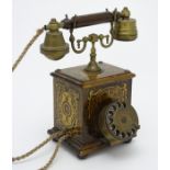 An Edwardian table telephone, with cylindrical dial and one-piece handset,