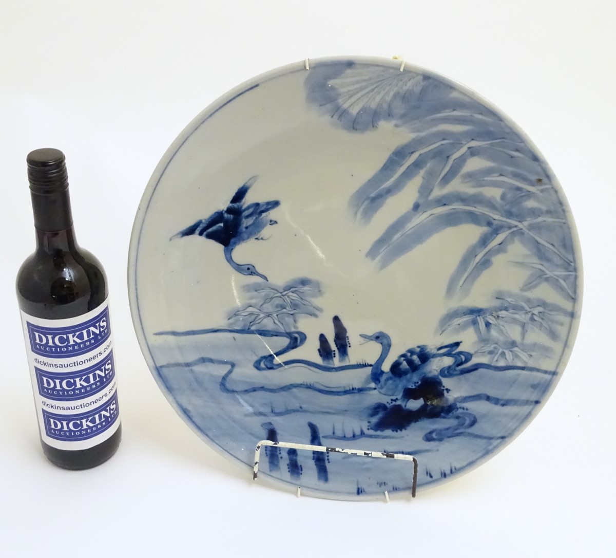 An oriental blue and white charger with hand painted decoration of birds in a landscape. Approx.