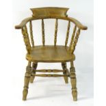 An early 20thC elm smokers bow chair,