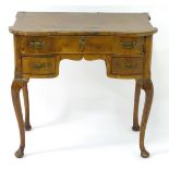 An early 19thC walnut lowboy with a castellated top edge above a single long drawer and two short