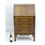 An early 20thC walnut bureau with a panelled fall opening to reveal fitted compartments and drawers