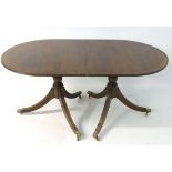 An early 20thC mahogany Regency style dining table,