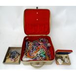 A vintage suitcase containing assorted jewellery, beads etc.