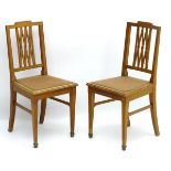 A pair of early 20thC satinwood side chairs having ebonised stringing to the frame and having a